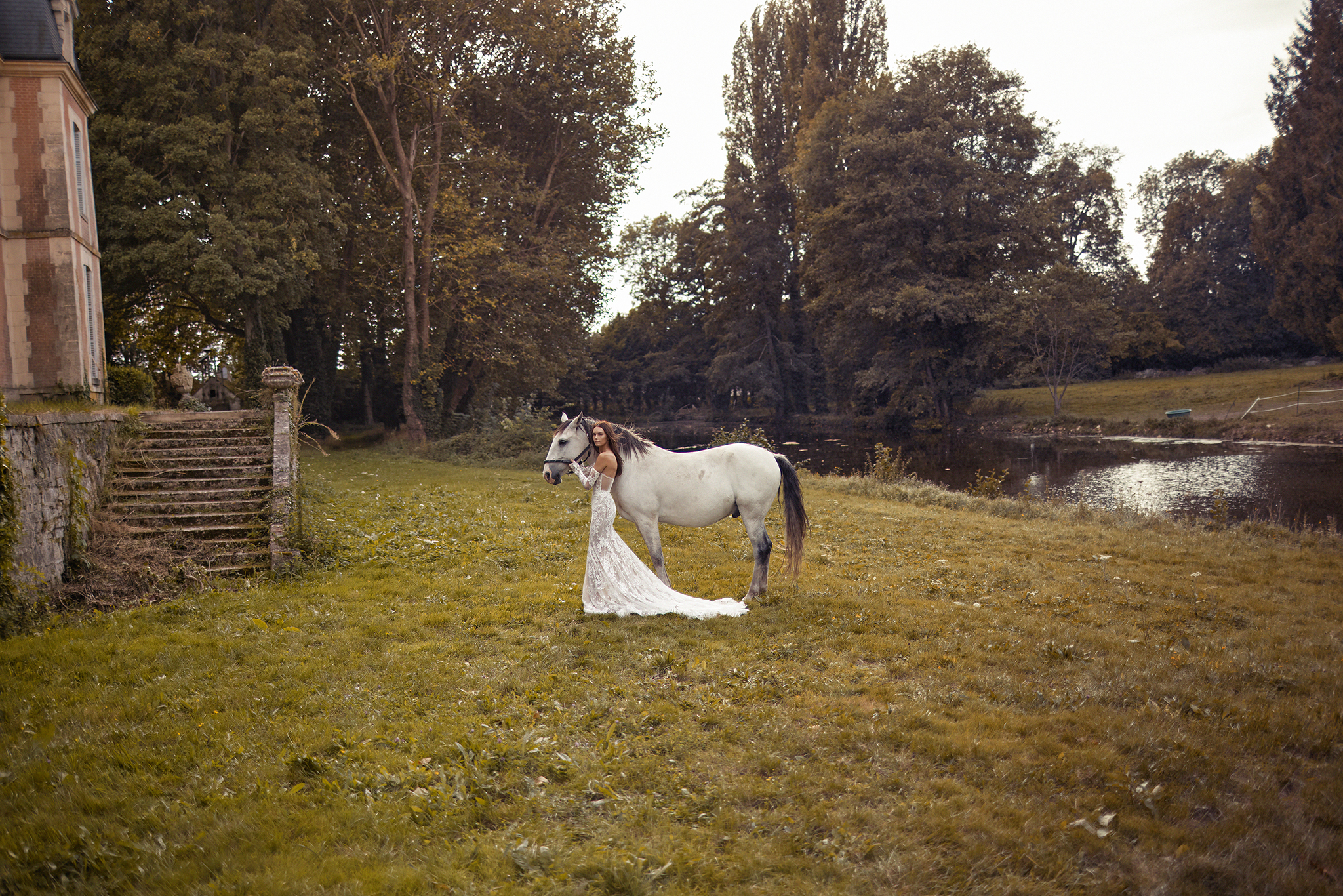 Bride in Lace wedding gown with a horse in country scape