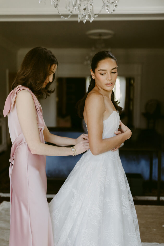 woman helping bride bustle