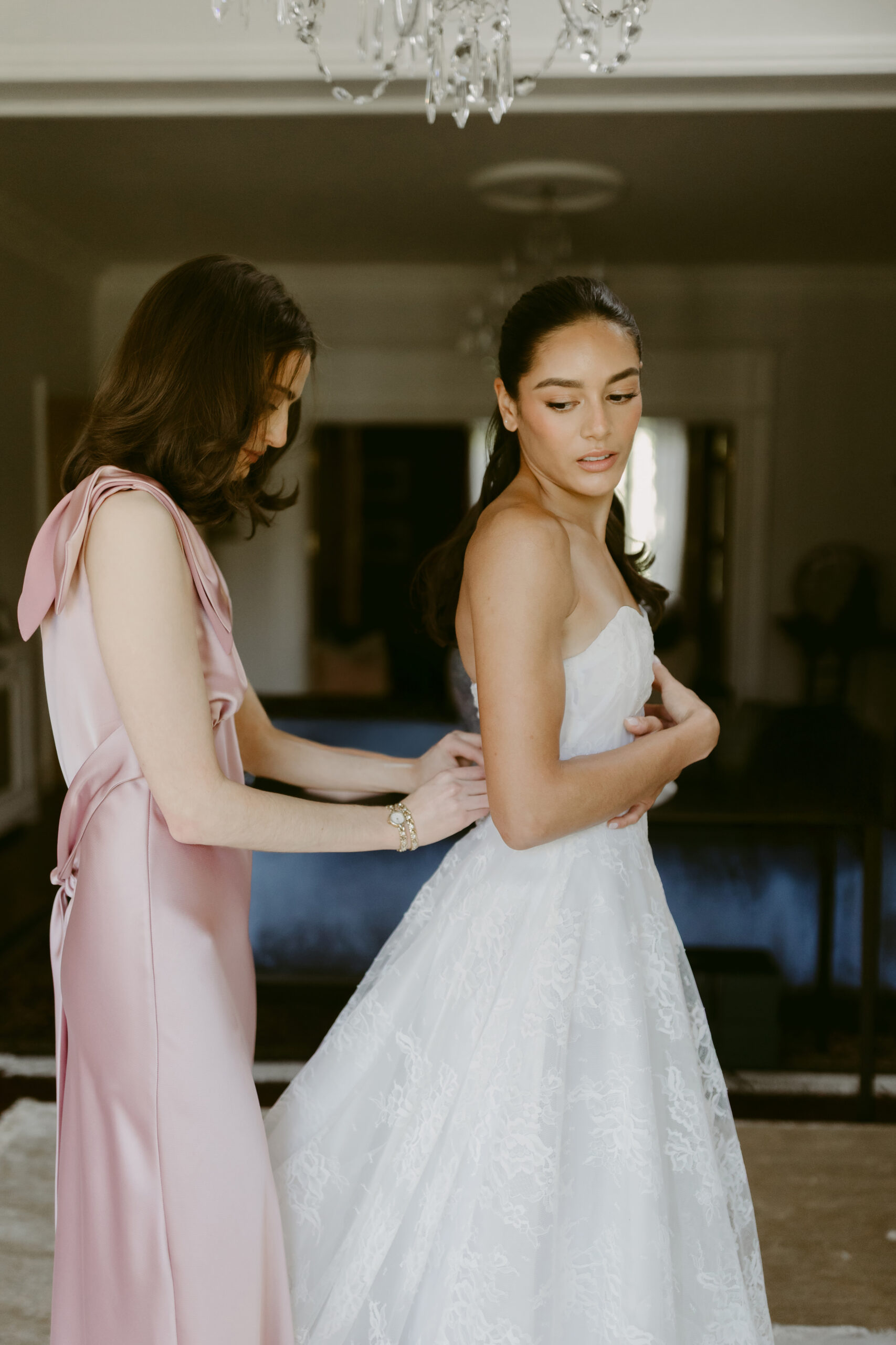woman helping bride bustle